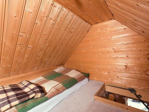 a small room with a bed in a wooden cabin at Einladende Ferienwohnung mit Außenpool in Beerheide