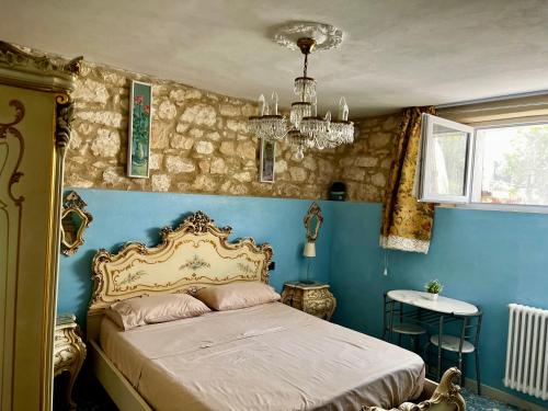 - une chambre avec un lit aux murs bleus et un lustre dans l'établissement Villa Angelina Via Barana 8, à Vérone