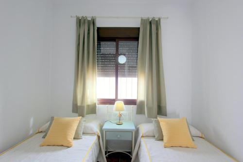 a bedroom with two beds and a window at Casa Rocio 1 in Conil de la Frontera