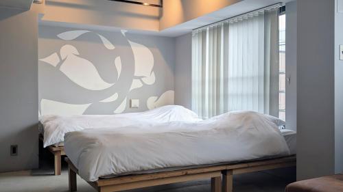 a bedroom with a bed and a large window at ART HOTELS SHIBUYA in Tokyo