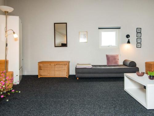 a living room with a bed and a mirror at 6 person holiday home in Ringkøbing in Ringkøbing