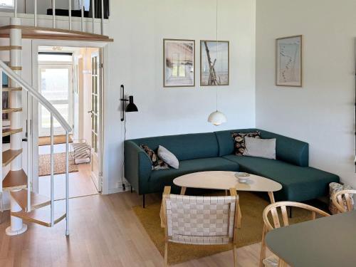 a living room with a green couch and a table at 6 person holiday home in Ringkøbing in Ringkøbing