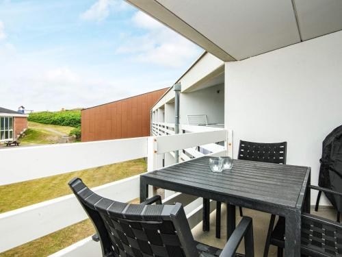 a table and chairs on the balcony of a house at 6 person holiday home in Ringkøbing in Ringkøbing