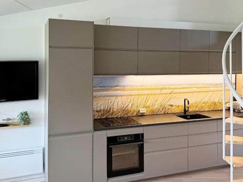 a kitchen with a painting on the wall at 6 person holiday home in Ringkøbing in Ringkøbing