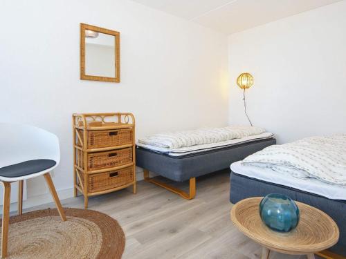 a bedroom with two beds and a table and a mirror at 6 person holiday home in Ringkøbing in Ringkøbing