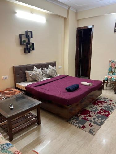 a bedroom with a large bed and a table at Elite Heaven Retreat 1 BHK Budget Home Stay Tapovan in Tapovan