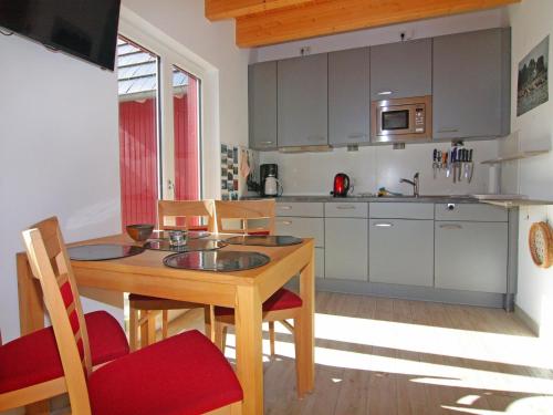 a kitchen with a wooden table and chairs and a kitchen with a sink at Semi-detached house, Zingst in Zingst