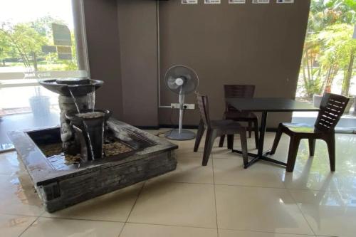 una fontana in una stanza con sedie e un tavolo di Dancenter KLIA Formerly Bary Inn a Sepang