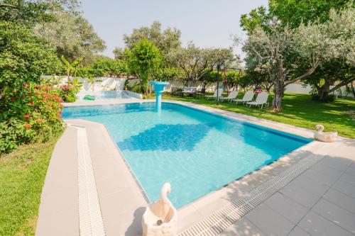 a swimming pool with a dolphin in the middle of it at Sunset Apartments in Archangelos
