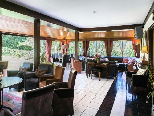 a waiting room with couches and tables and windows at Atmospheric holiday home in Durbuy with sauna in Septon