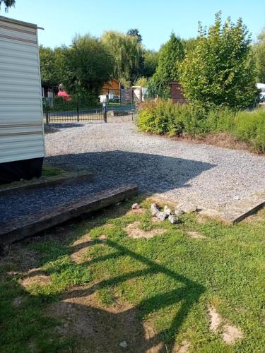 a gravel driveway next to a building at logement caravane in Les Journeux