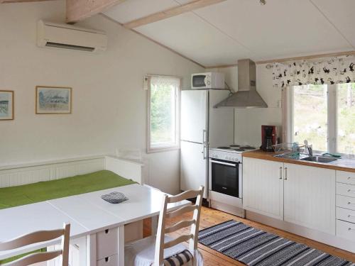 a kitchen with a table and a stove top oven at 4 person holiday home in SMEDSTORP in Smedstorp