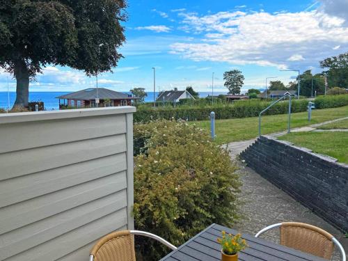 a patio with a table and chairs and the ocean at 4 person holiday home in Allinge in Allinge
