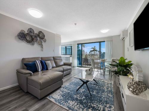 a living room with a couch and a table at Meridian Alex Beach Apartments in Alexandra Headland