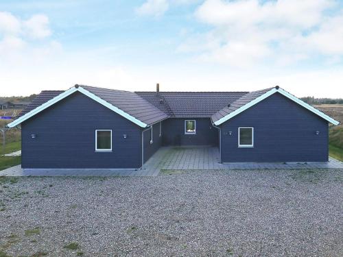 a large blue house with a garage at 22 person holiday home in Jerup in Jerup