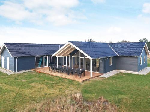 a house with a deck and a solar roof at 22 person holiday home in Jerup in Jerup
