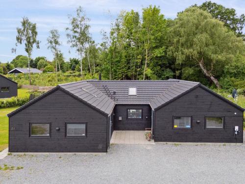 a black house with a gambrel roof at 5 star holiday home in Dronningmølle in Dronningmølle