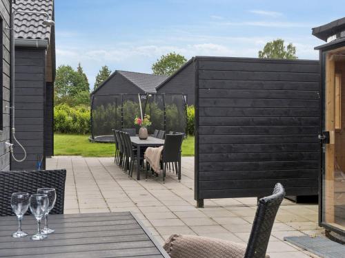a patio with a table and chairs and a fence at 5 star holiday home in Dronningmølle in Dronningmølle