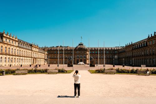a woman standing in front of a large building at Gästehaus Sophienstraße in Stuttgart