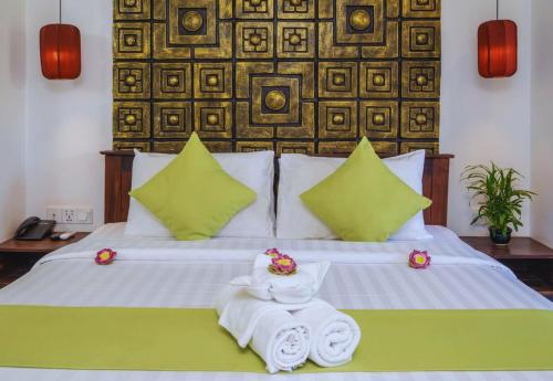 a bedroom with a bed with towels on it at Angkor Land House in Phumĭ Réach Born