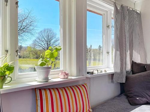 a room with two windows and a striped pillow at 2 person holiday home in Brösarp in Brösarp