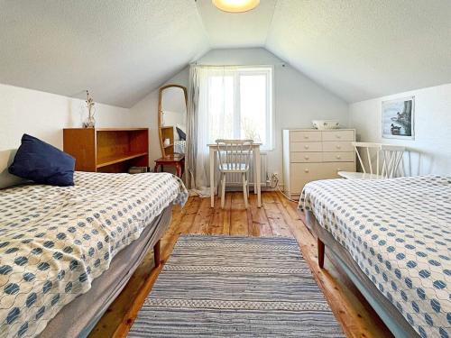 a bedroom with two beds and a table and a window at 2 person holiday home in Brösarp in Brösarp