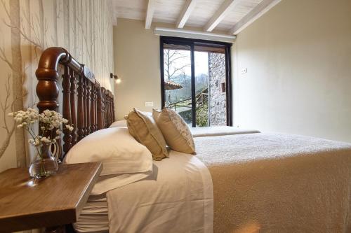 a bedroom with a large bed and a window at Bonalife - Senda del Oso in Sabadia