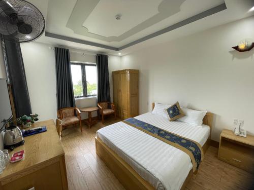a hotel room with a bed and a desk and window at My Dream Hotel in Vung Tau