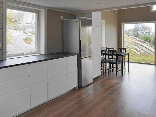 a kitchen with a refrigerator and a table and chairs at 5 person holiday home in KLÖVEDAL in Klövedal