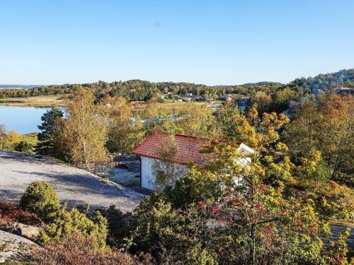 a small house on a hill with trees and a lake at 5 person holiday home in KLÖVEDAL in Klövedal
