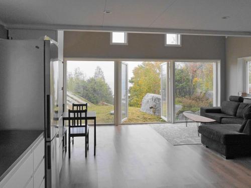 a living room with a couch and a table and chairs at 5 person holiday home in KLÖVEDAL in Klövedal