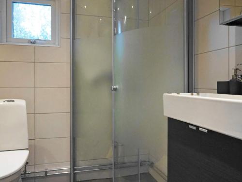 a bathroom with a glass shower and a sink at 5 person holiday home in KLÖVEDAL in Klövedal