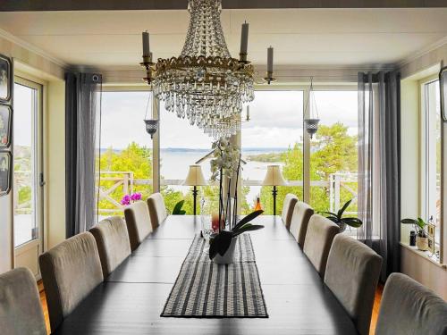 a dining room with a long table and a chandelier at 5 person holiday home in KLÖVEDAL in Klövedal