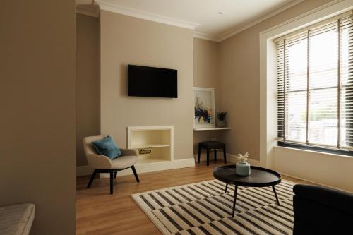 a living room with a tv and a chair and a table at GuestReady - Modern haven with garden in Dublin in Dublin