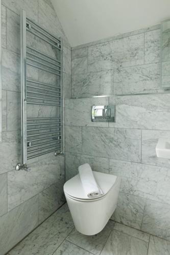 a white bathroom with a toilet and a shower at GuestReady - Modern haven with garden in Dublin in Dublin