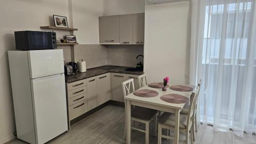 a kitchen with a table and a white refrigerator at Apartamente Felix in Baile Felix