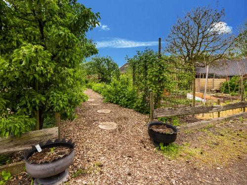 a garden with two flower pots and a fence at Vibrant Apartment in Baflo by Op de Roemte in Baflo