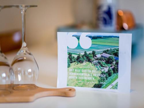 a book sitting on a table next to a wine glass at Vibrant Apartment in Baflo by Op de Roemte in Baflo