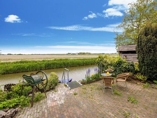 a brick patio with chairs and a river at Vibrant Apartment in Baflo by Op de Roemte in Baflo