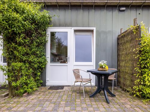 a table and chairs in front of a door at Vibrant Apartment in Baflo by Op de Roemte in Baflo