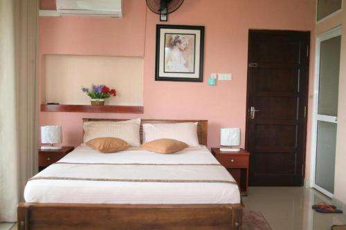 a bedroom with a large bed with two night stands at The Springfields Kandy Previously Madara Residence Kandy in Kandy