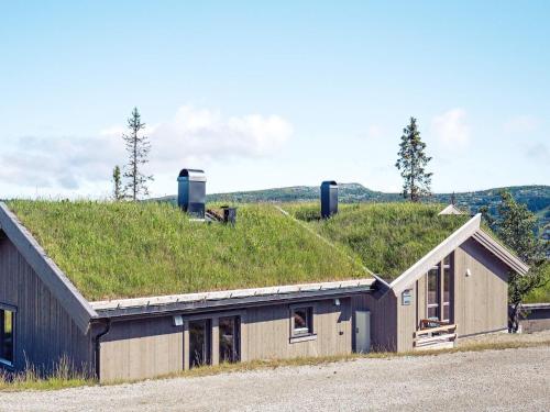 a building with a grassy roof with a building with a window at 10 person holiday home in Fåvang in Favang