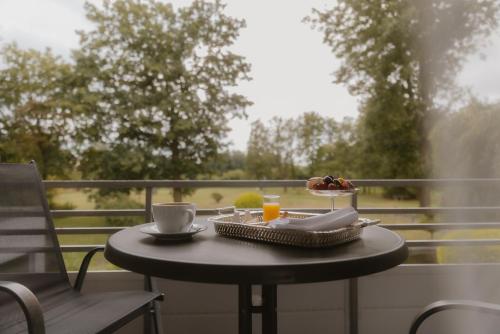 a table with a plate of food and a cup of orange juice at Landhotel Stähle in Schüttorf