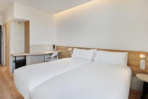 a bedroom with a large white bed and a desk at B&B HOTEL Porto Centro Massarelos in Porto