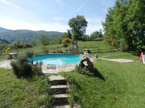 a swimming pool in the middle of a grassy field at Rustic Holiday Home in Ortignano with Swimming Pool in Castel Focognano