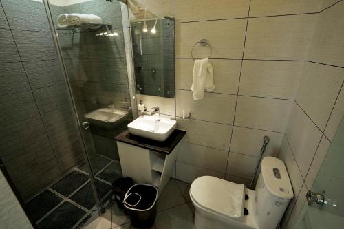 a bathroom with a toilet and a sink and a shower at IRON BRIDGE COVE in Meppādi