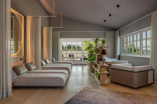 a large living room with couches and windows at DAS AFFALTERBACH, Stuttgart, Autograph Collection in Affalterbach