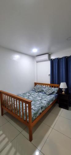 a bed in a room with a blue curtain at Bright & Spacious 3BR & Pool in Suva