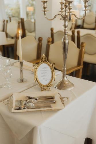 a table with a clock and silverware on it at Landhotel Stähle in Schüttorf