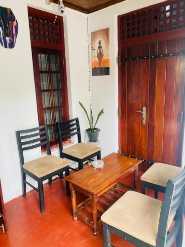 a table and two chairs and a wooden table and chairs at OSRA cottage and tourism in Katunayake